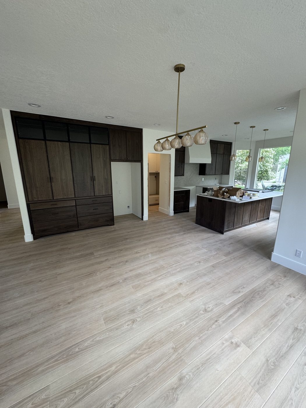 After: walnut cabinetry, island and brass pendants