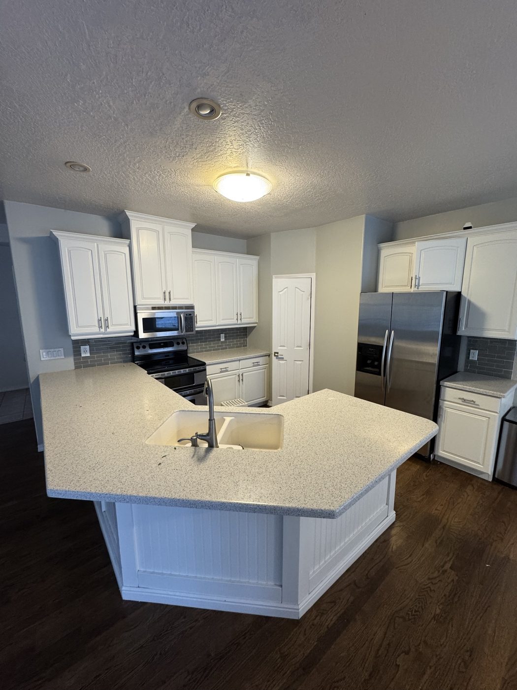 Before: dated white kitchen with speckled countertops