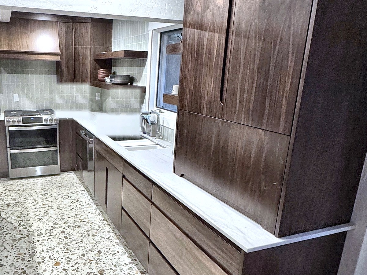 Basement apartment kitchen with walnut cabinetry, quartz counters, and terrazzo floor