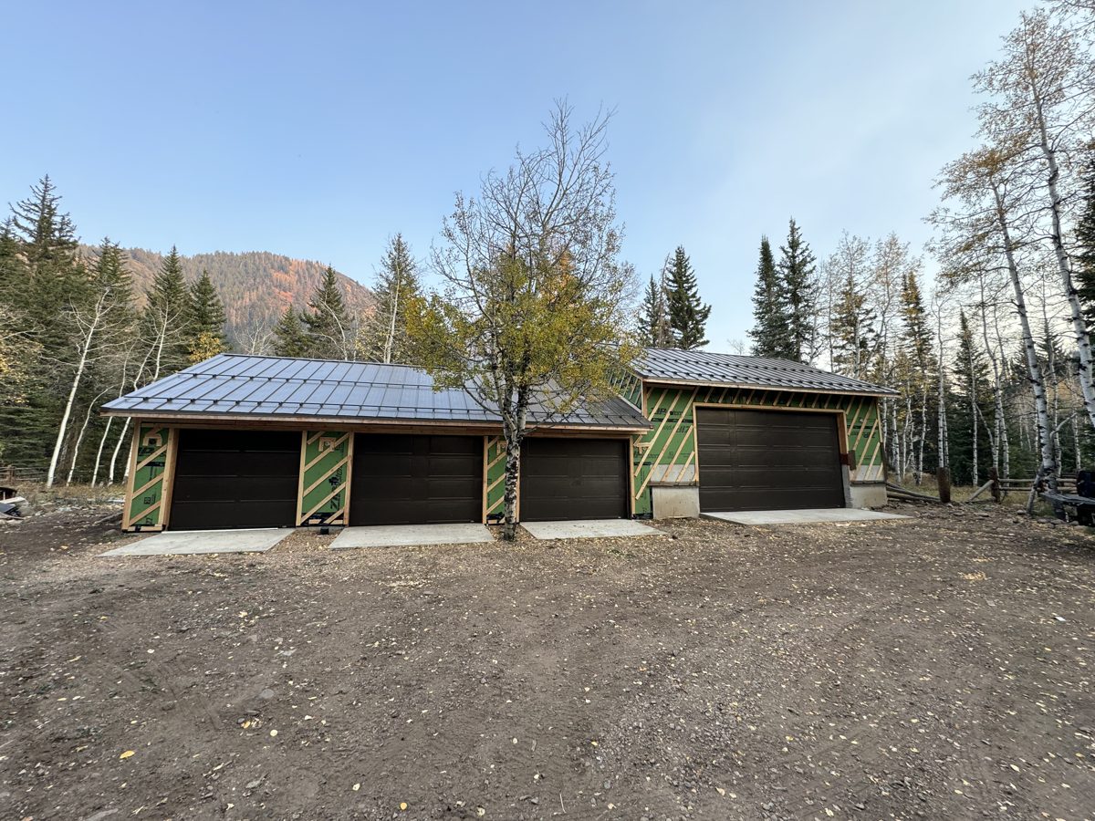 New four-bay detached garage with dark cedar siding